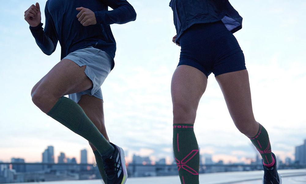 Men running on sand with compression socks.