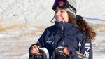 Janneke Berghuis, sitting on the ground wearing a blue jacket.